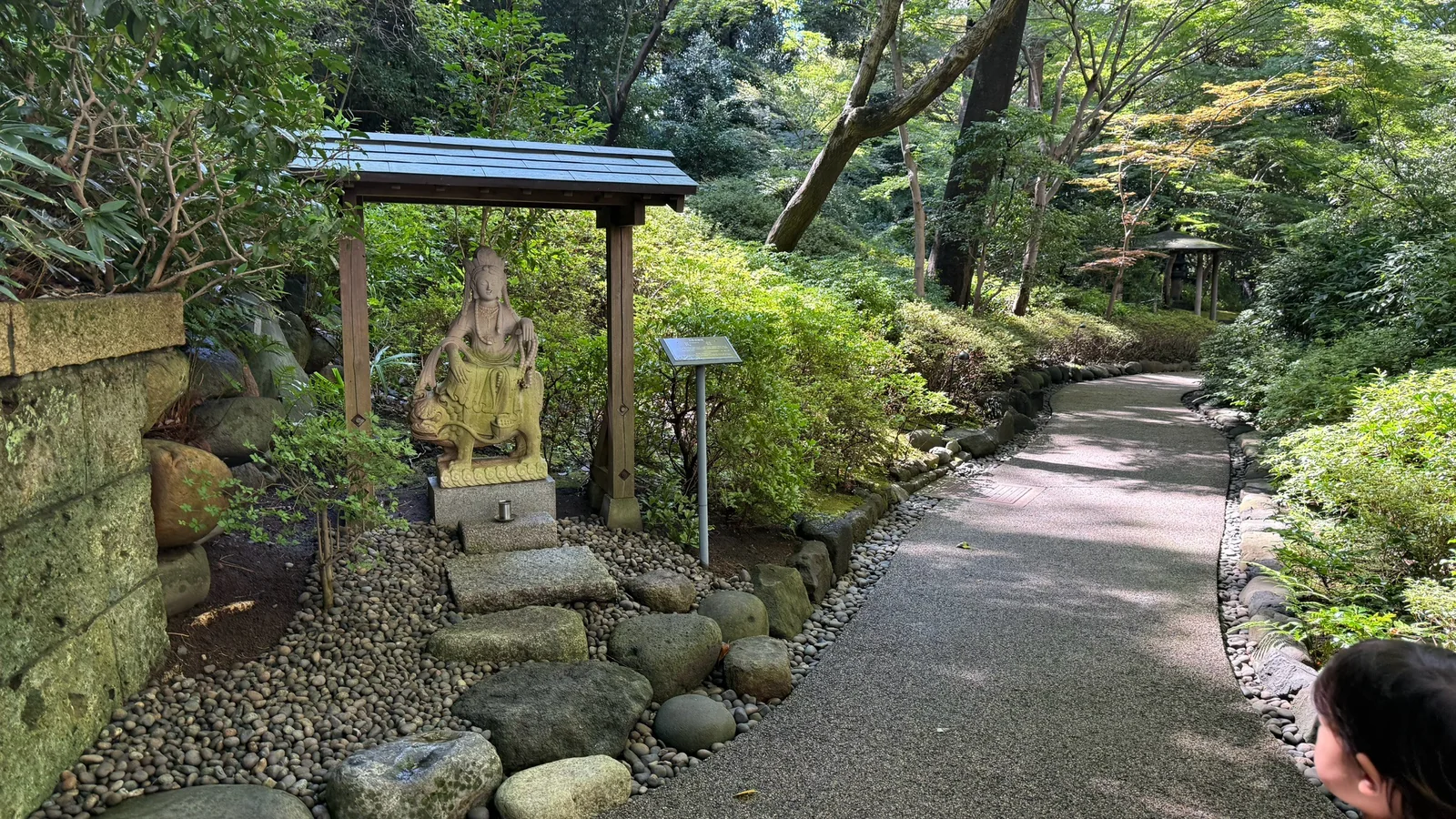 屋根の下に石像が置かれた散策路の一角
